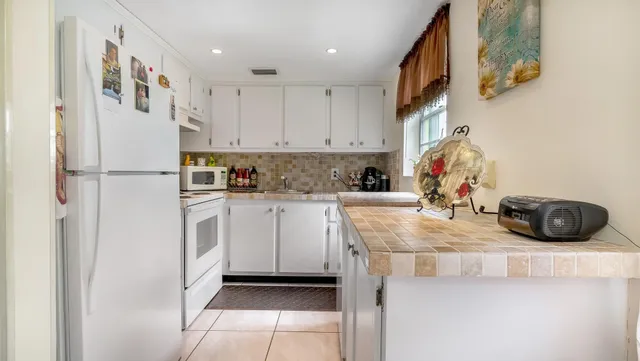 a kitchen with a sink a refrigerator and cabinets