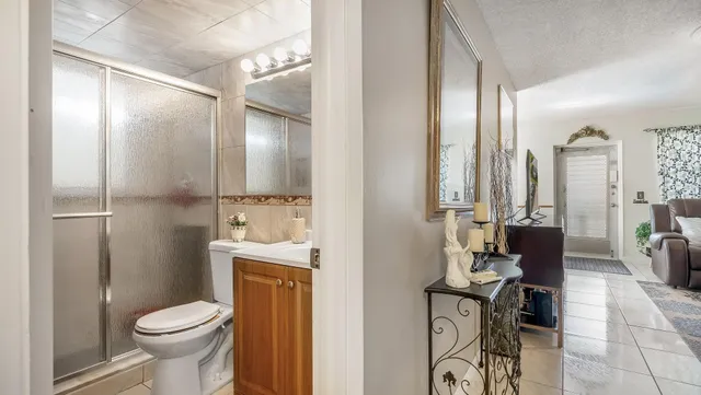 a bathroom with a granite countertop toilet a sink and a mirror
