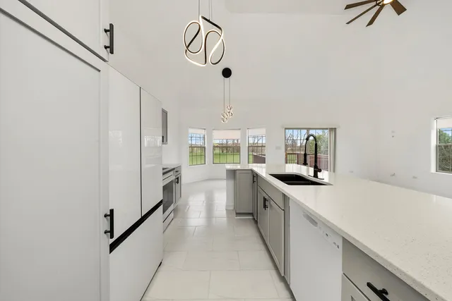 a kitchen with white cabinets stainless steel appliances and sink