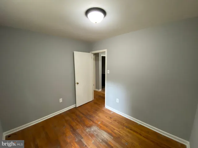 an empty room with wooden floor and mirror