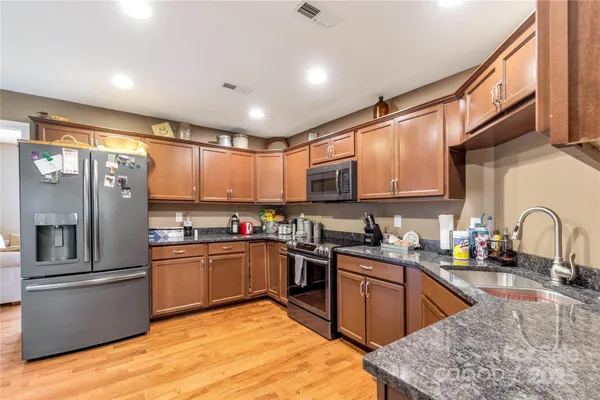 a kitchen with stainless steel appliances granite countertop a sink and cabinets