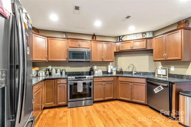 a view of a kitchen with fridge and wooden floor