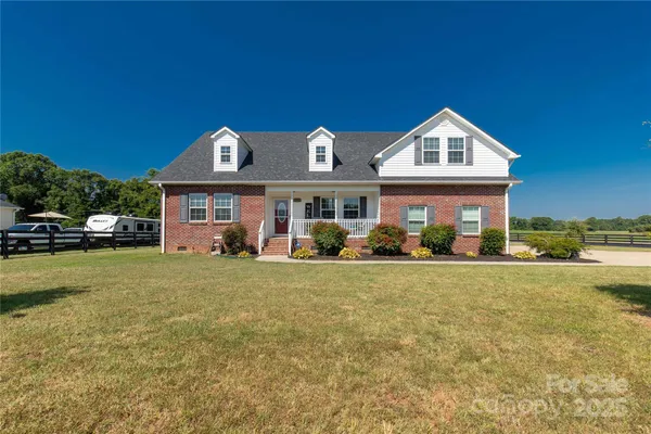 a front view of a house with a garden and yard