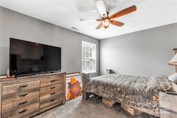 a bedroom with a bed and a chandelier