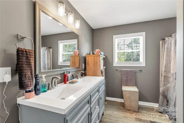 an empty room with windows and ceiling fan