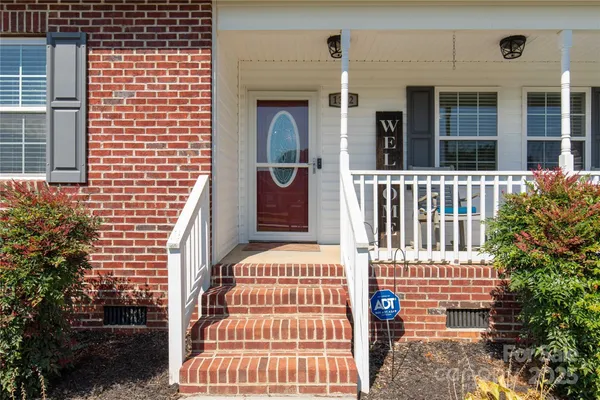 a view of a brick house with plants and windows