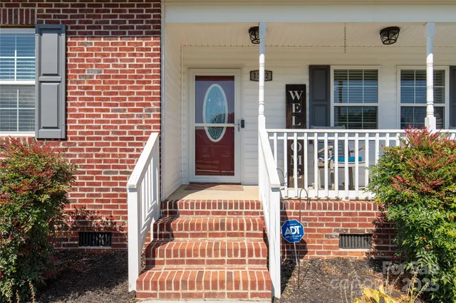 a view of a brick house with plants and windows