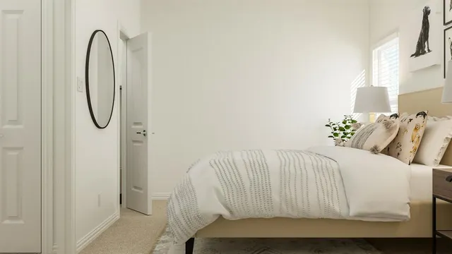 a bed sitting in a bedroom next to a bathroom