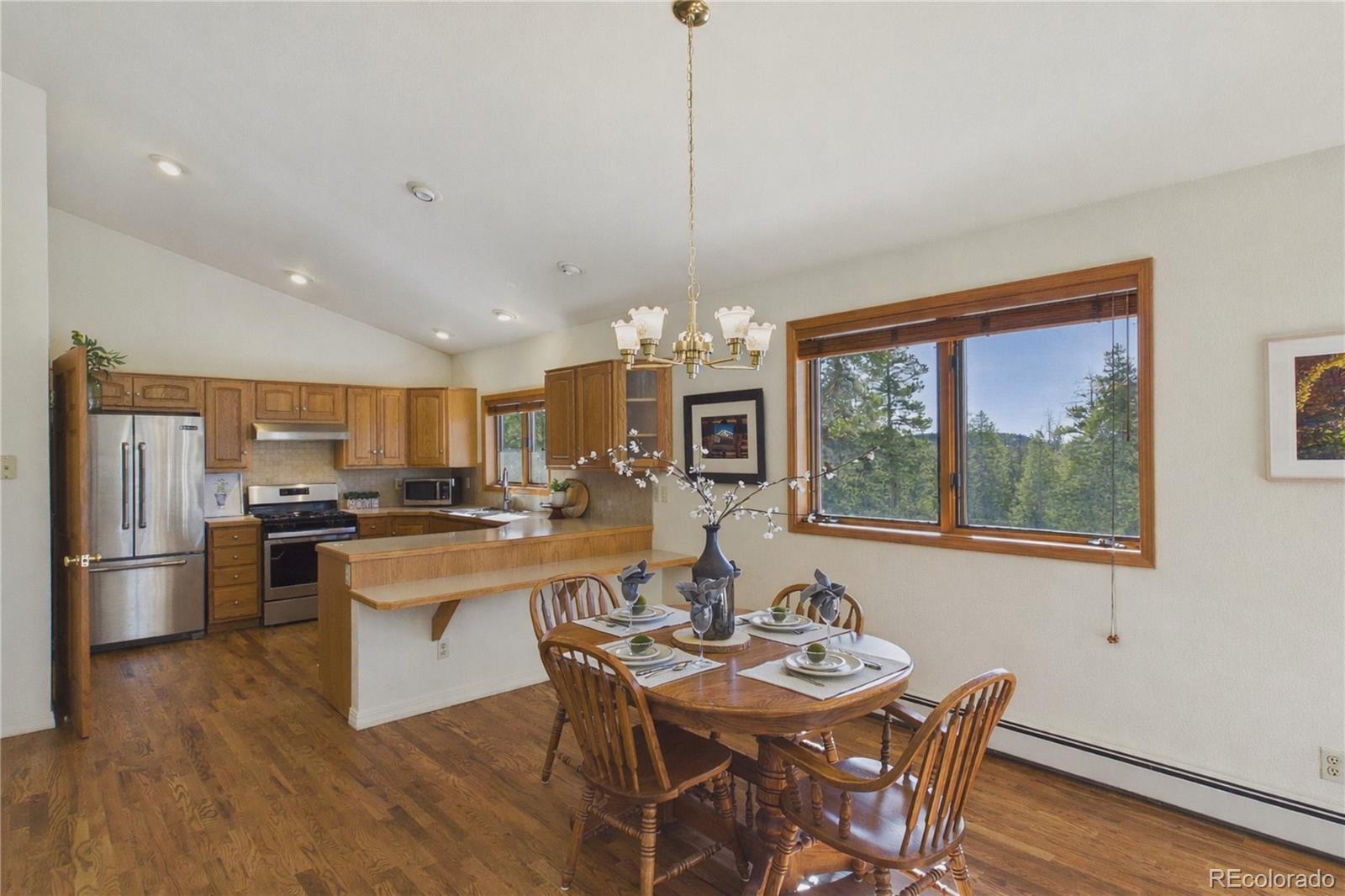 10798 Crystal Way Morrison, CO 80465 - Photo 14 of 36 a kitchen with stainless steel appliances granite countertop a stove and a dining table with kitchen view