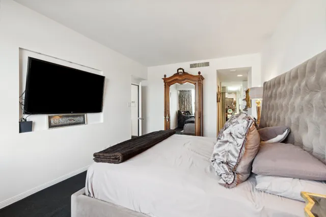 a bedroom with a bed and a flat screen tv