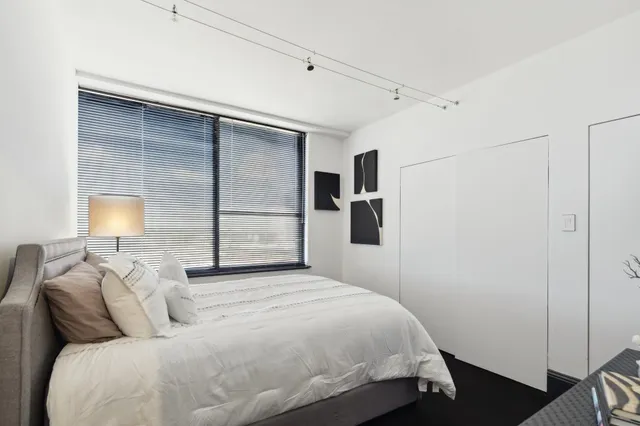 a bedroom with a bed and a lamp