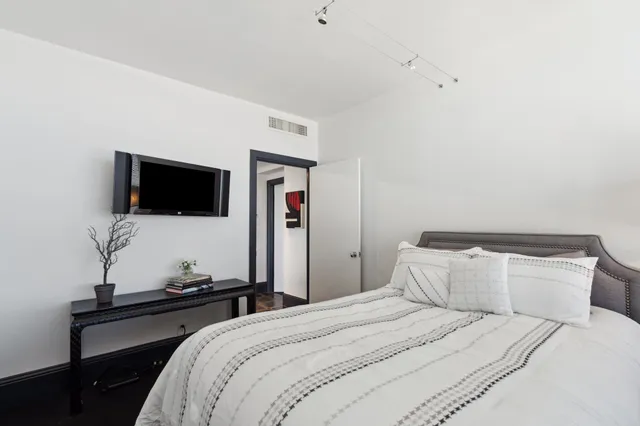 a bedroom with a bed and a flat screen tv