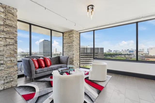 a living room with furniture kitchen view and a large window