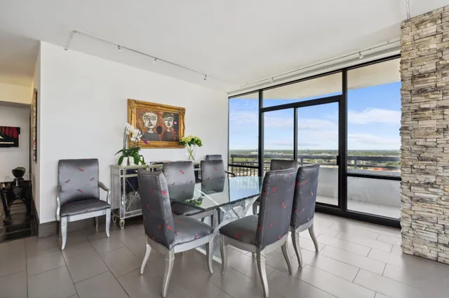 a dining room with furniture and large windows