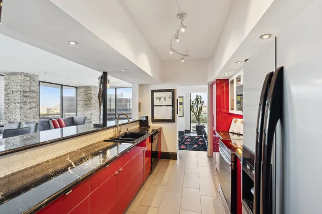 a large living room with stainless steel appliances granite countertop a couch and a large window