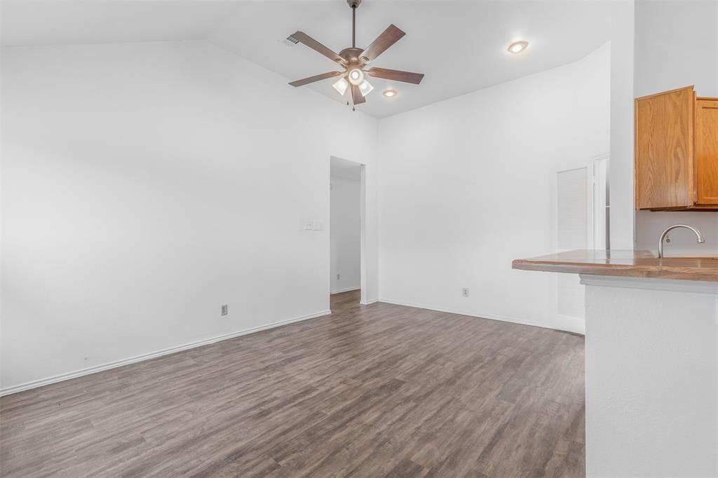 1313 Clover Drive Allen, TX 75002 - Photo 11 of 30 a view of a kitchen with wooden floor and a ceiling fan