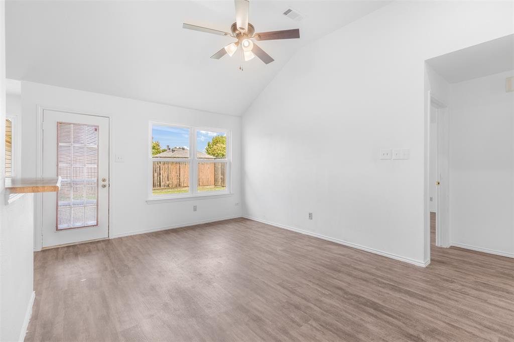 1313 Clover Drive Allen, TX 75002 - Photo 13 of 30 an empty room with wooden floor chandelier fan and windows