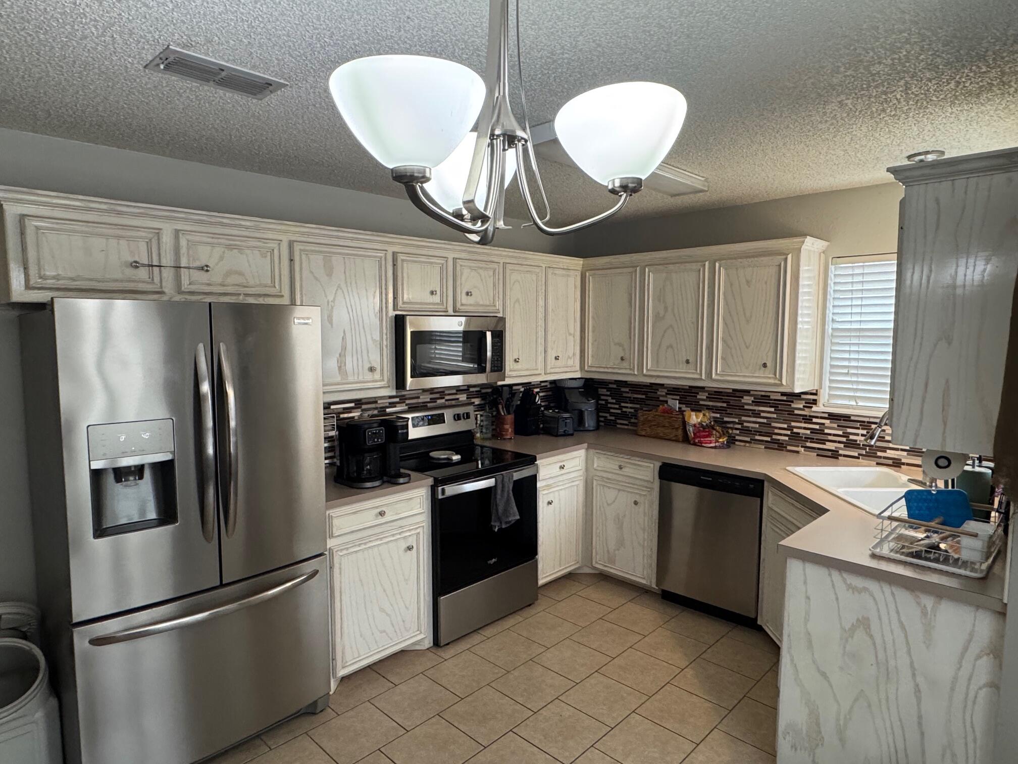 1906 81st Street Lubbock, TX 79423 - Photo 2 of 14 a kitchen with stainless steel appliances granite countertop a refrigerator a stove a sink and a refrigerator
