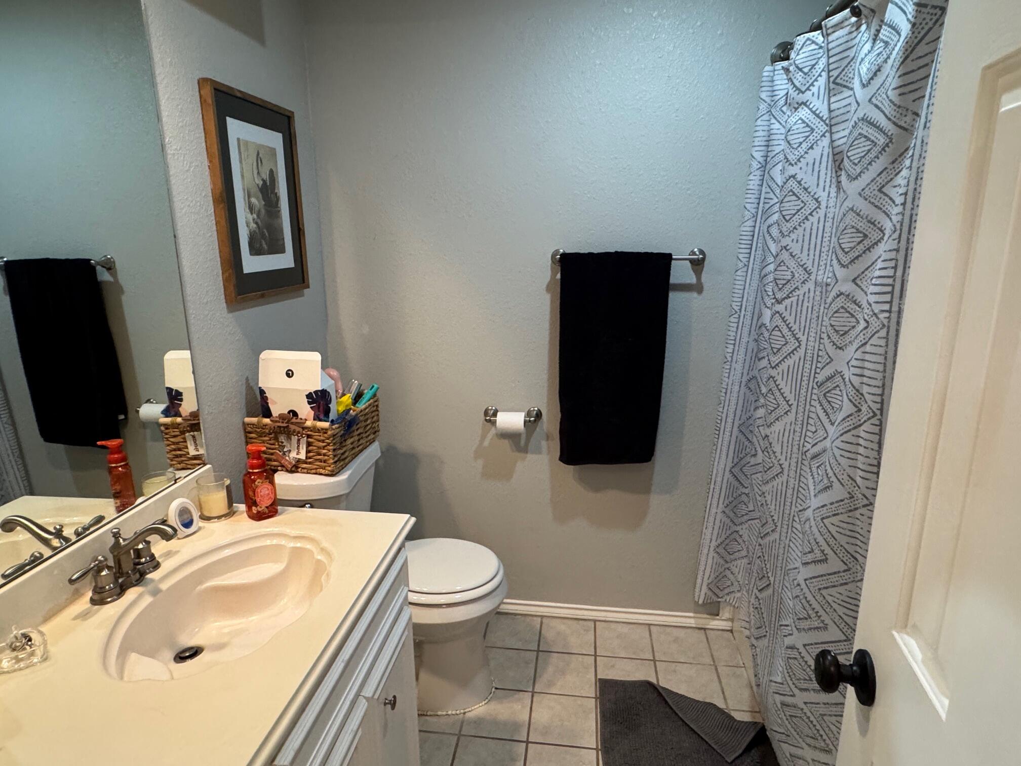 1906 81st Street Lubbock, TX 79423 - Photo 8 of 14 a bathroom with a sink toilet and shower
