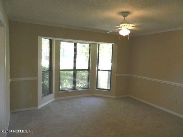 1649 Derringer Road Jacksonville, FL 32225 - Photo 17 of 50 en empty room with windows and chandelier