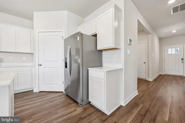a view of a kitchen with wooden floor and electronic appliances