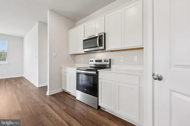 a kitchen with stainless steel appliances granite countertop a stove a microwave and a hard wood floors