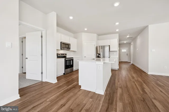 a view of a kitchen with wooden floor and electronic appliances