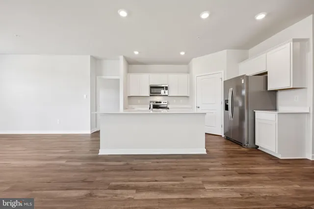 a view of kitchen refrigerator a sink and cabinets