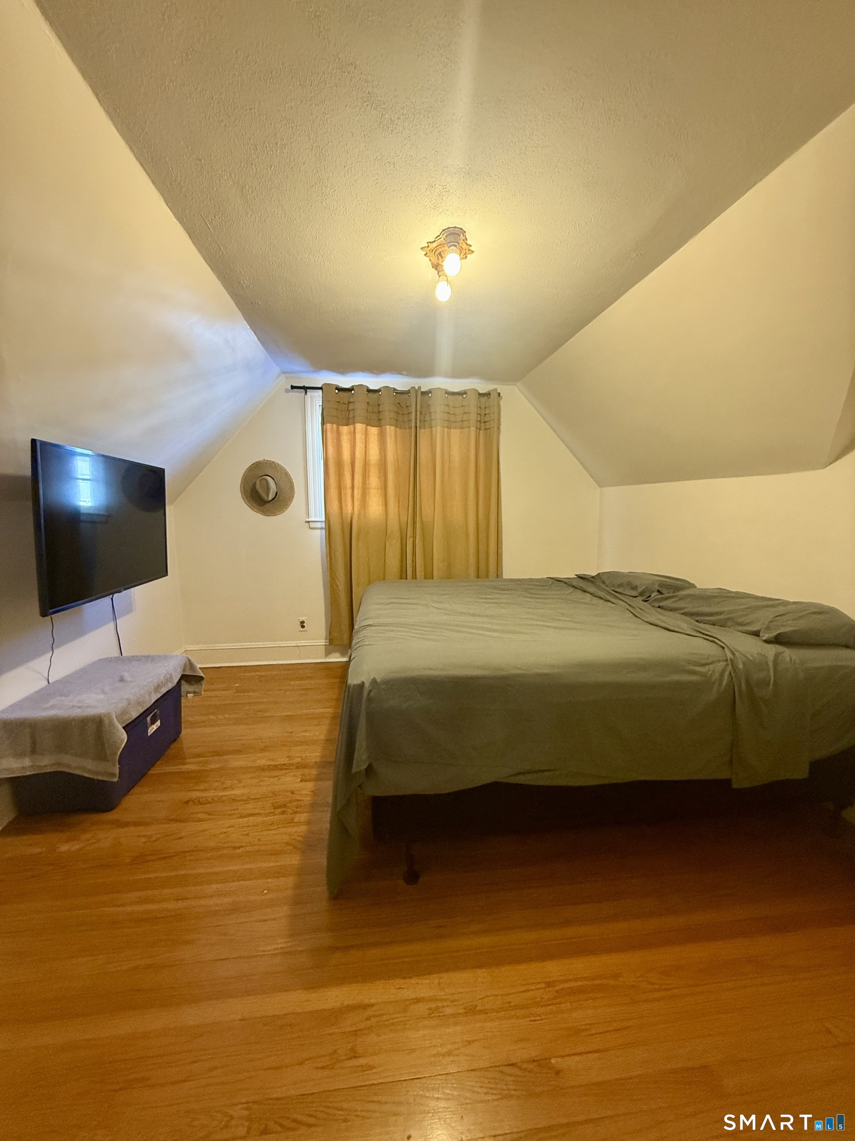 a bedroom with a bed and a flat screen tv