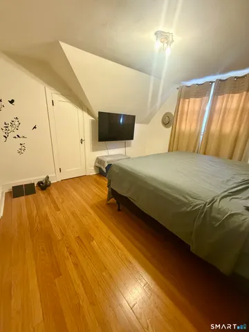 a bedroom with a bed and wooden floor