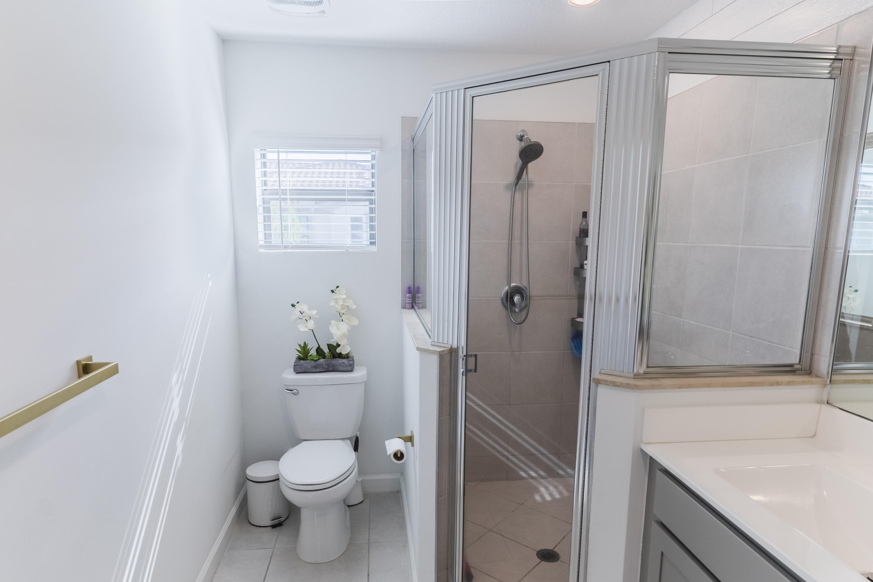 2025 Sugar Maple Drive Riviera Beach, FL 33410 - Photo 11 of 23 a bathroom with a granite countertop toilet a sink and a shower
