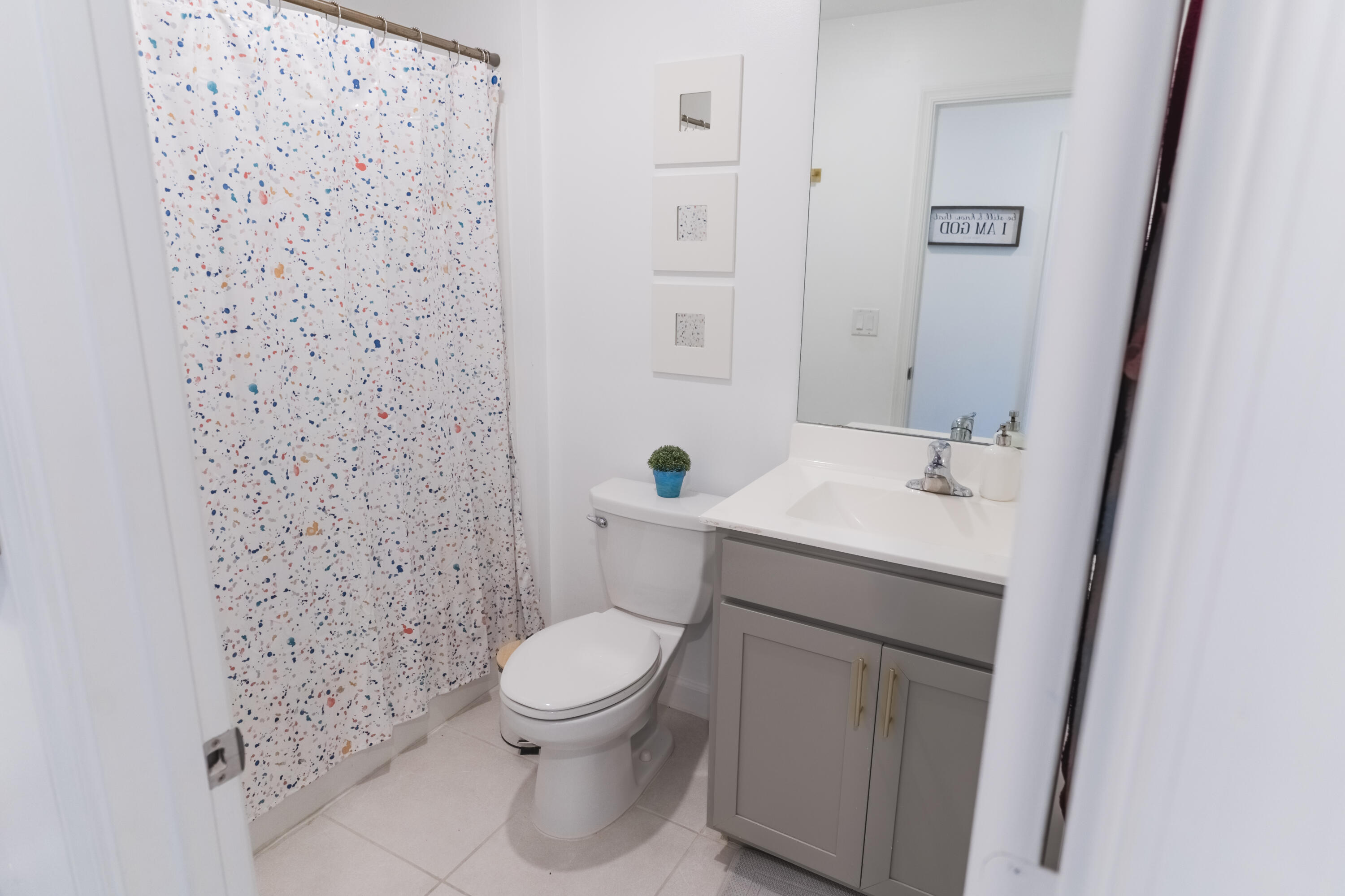 2025 Sugar Maple Drive Riviera Beach, FL 33410 - Photo 14 of 23 a white toilet sitting next to a bathroom sink