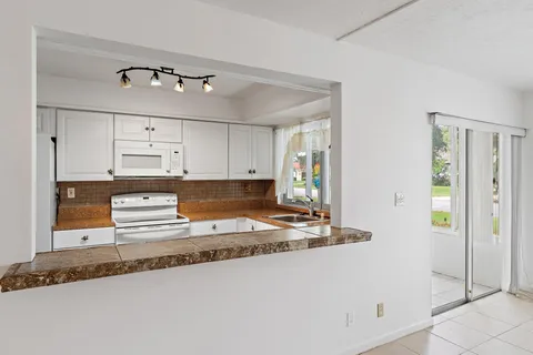 a kitchen with white cabinets and appliances