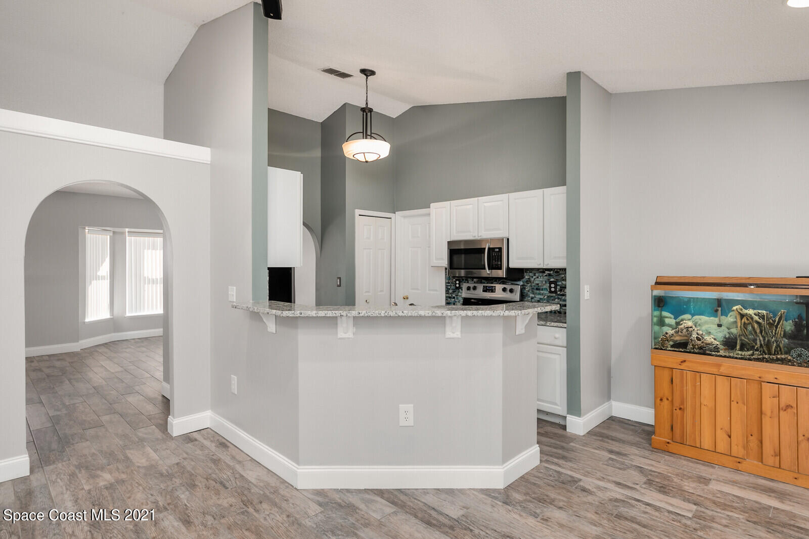 335 Gordon Road Northwest Palm Bay, FL 32907 - Photo 14 of 58 a kitchen with stainless steel appliances granite countertop a refrigerator a stove a microwave and wooden floor