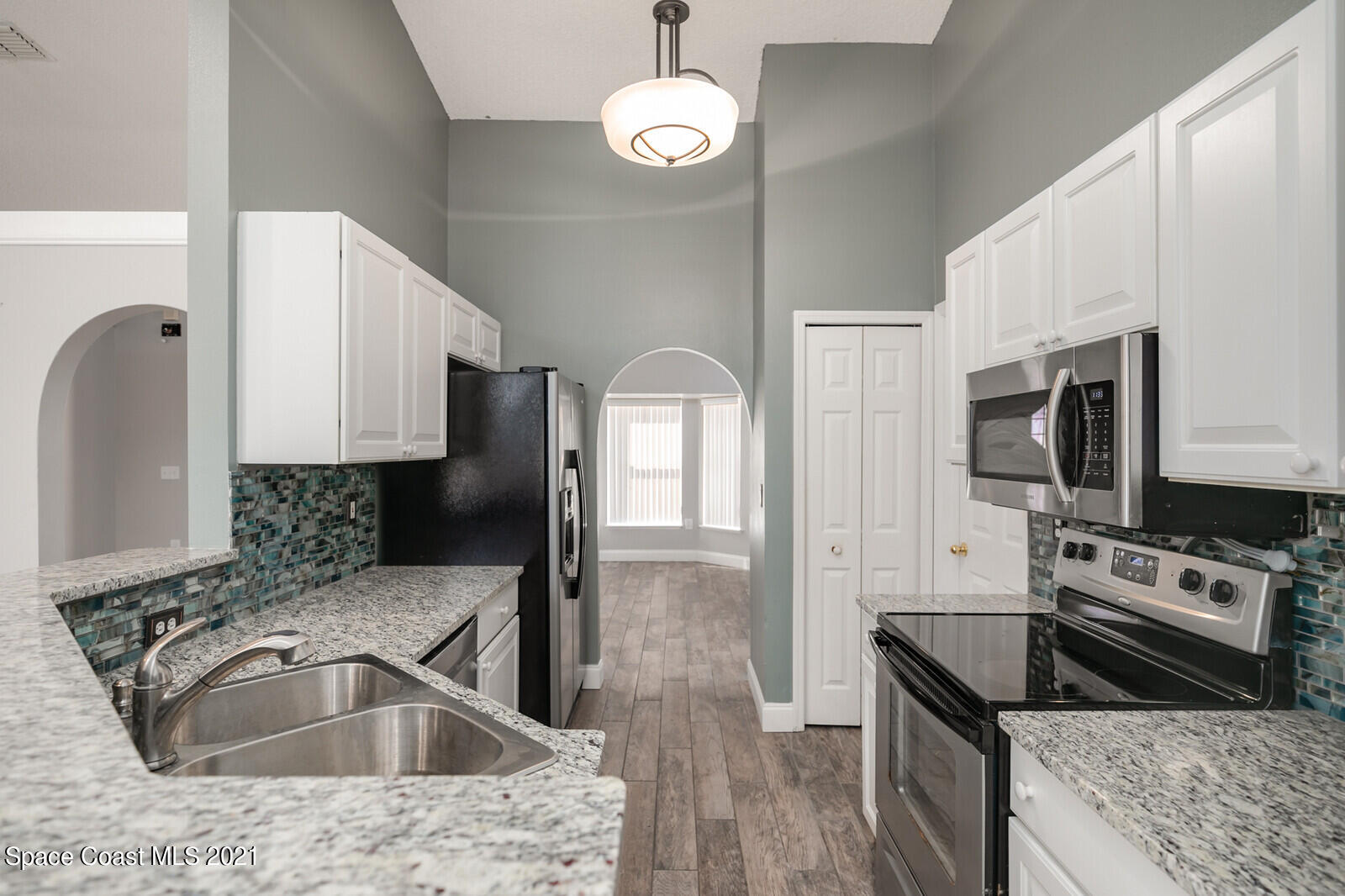 335 Gordon Road Northwest Palm Bay, FL 32907 - Photo 16 of 58 a kitchen with stainless steel appliances granite countertop a sink microwave and stove