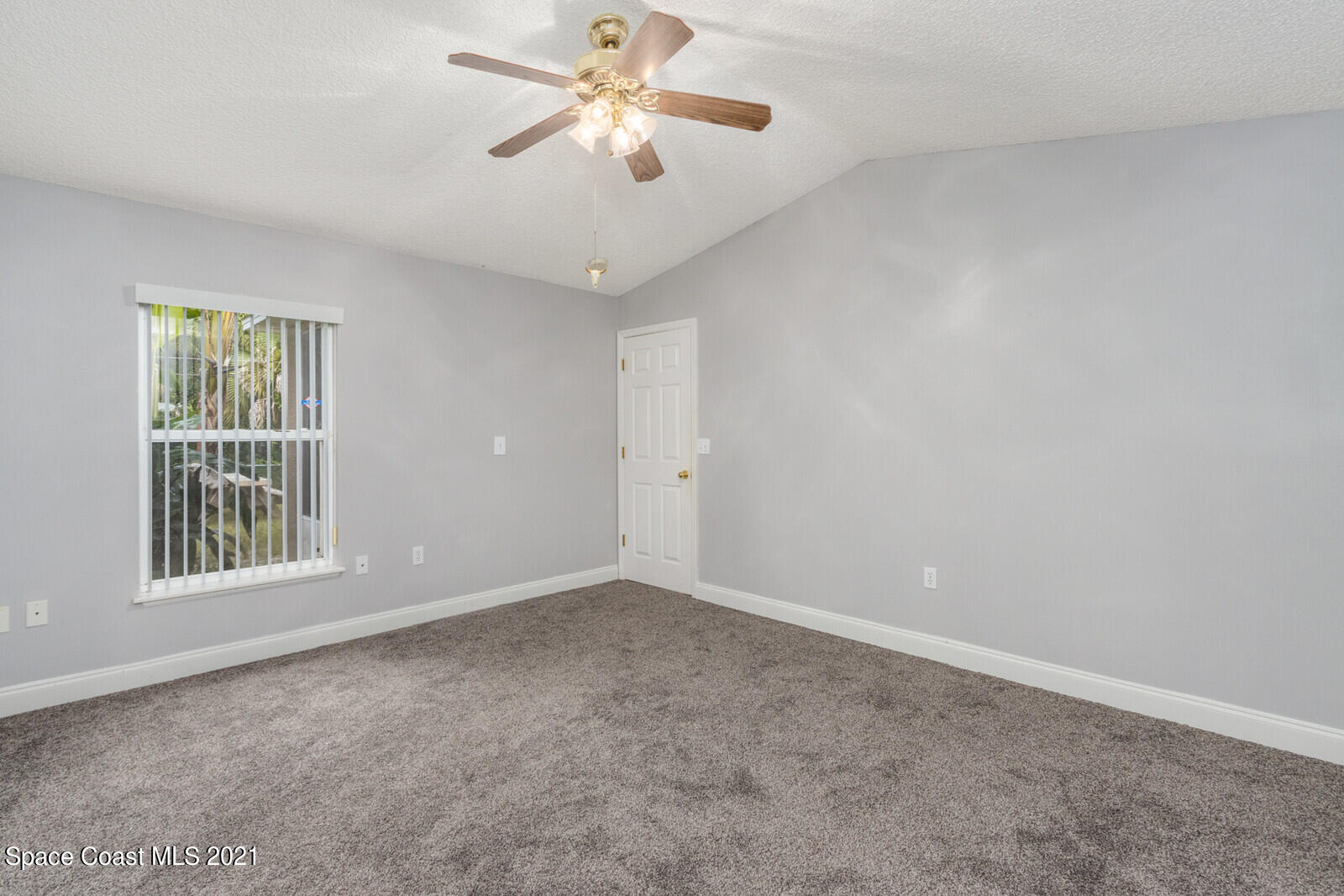 335 Gordon Road Northwest Palm Bay, FL 32907 - Photo 23 of 58 an empty room with windows and fan