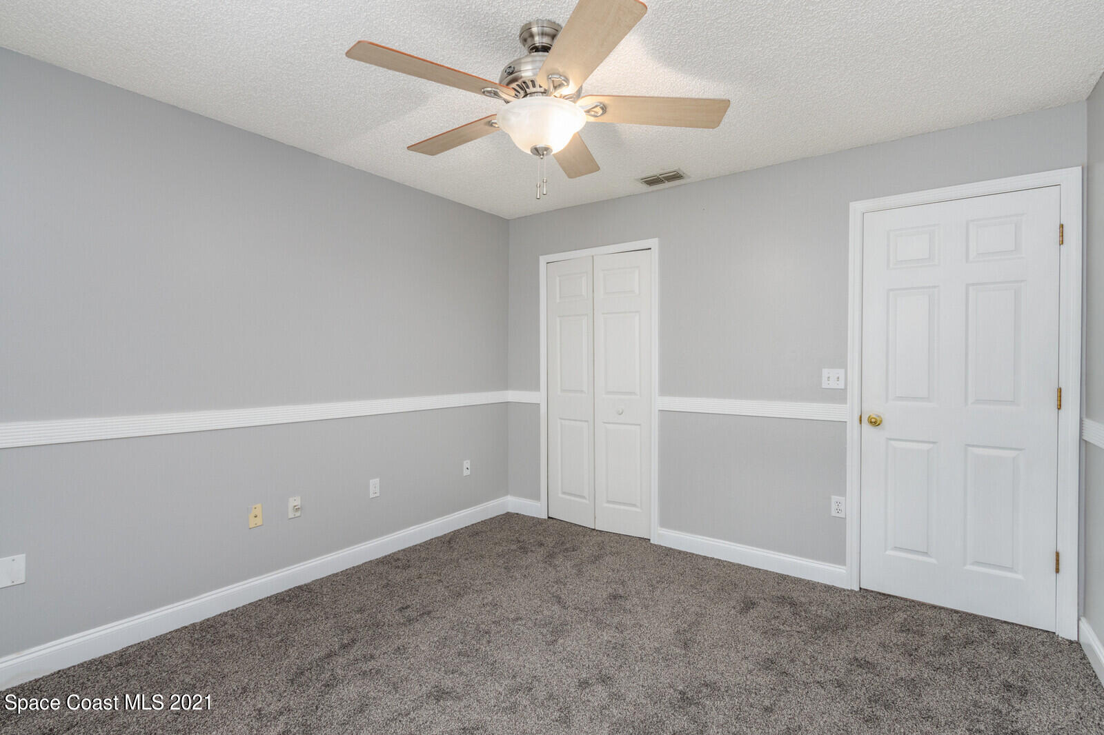 335 Gordon Road Northwest Palm Bay, FL 32907 - Photo 30 of 58 an empty room with closet and a chandelier fan