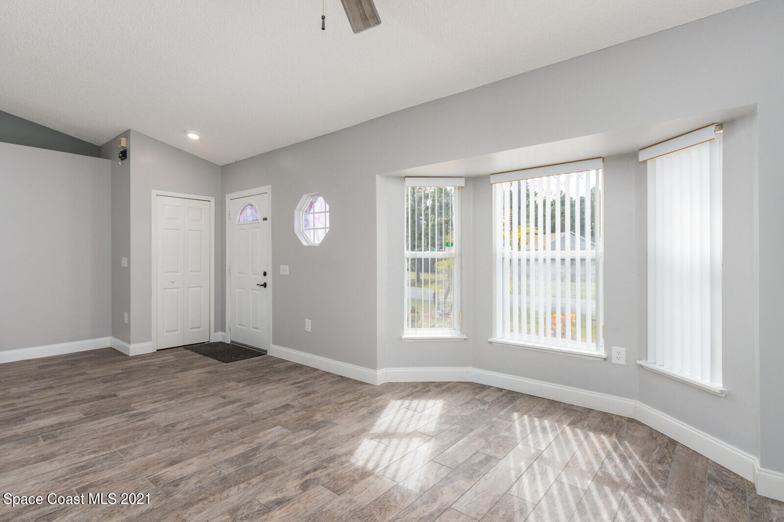 335 Gordon Road Northwest Palm Bay, FL 32907 - Photo 5 of 58 a view of an empty room with wooden floor and a window