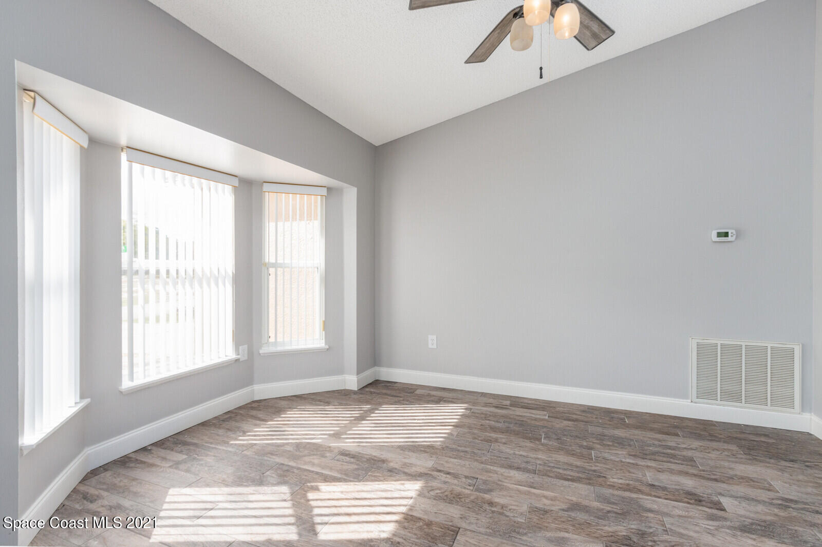 335 Gordon Road Northwest Palm Bay, FL 32907 - Photo 7 of 58 a view of empty room with wooden floor and fan
