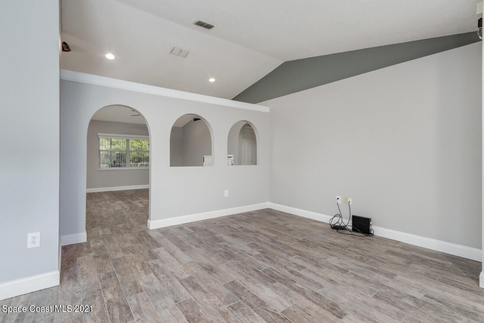 335 Gordon Road Northwest Palm Bay, FL 32907 - Photo 8 of 58 an empty room with wooden floor and windows