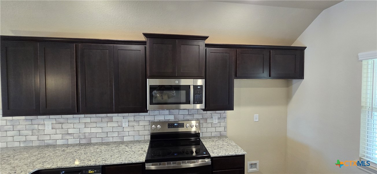 338 Monty Road Copperas Cove, TX 76522 - Photo 5 of 14 a kitchen with granite countertop a stove and a microwave