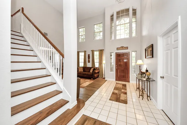 a spacious bedroom with a large bed and a chandelier