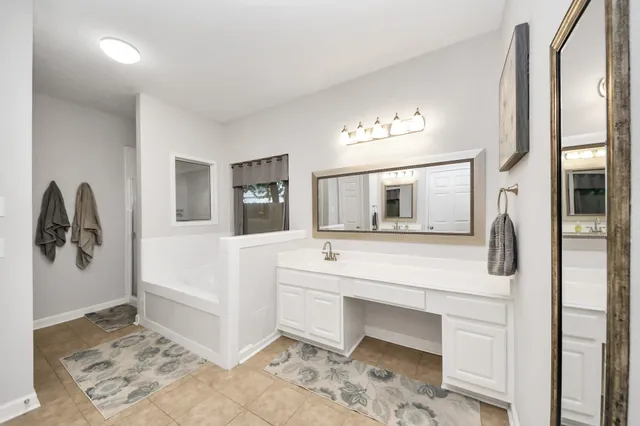 a spacious bedroom with a bed and a chandelier