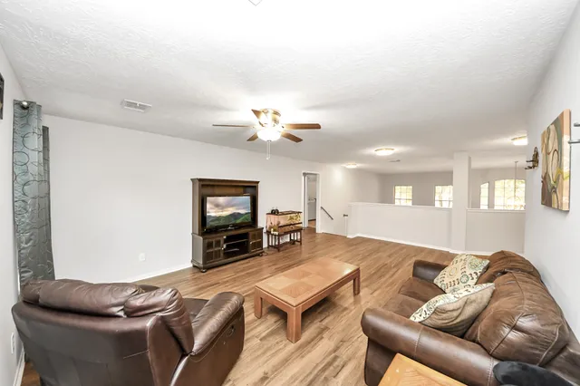 a living room with furniture and a chandelier