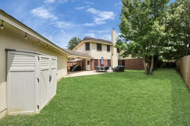 a front view of a house with a yard and trees