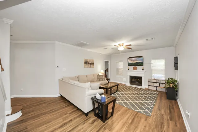 a living room with furniture a fireplace and a flat screen tv