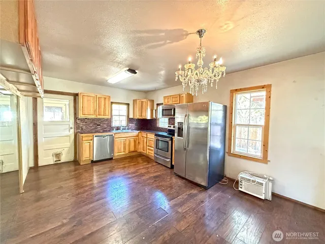 a view of a kitchen with granite countertop stainless steel appliances cabinets and a counter top space