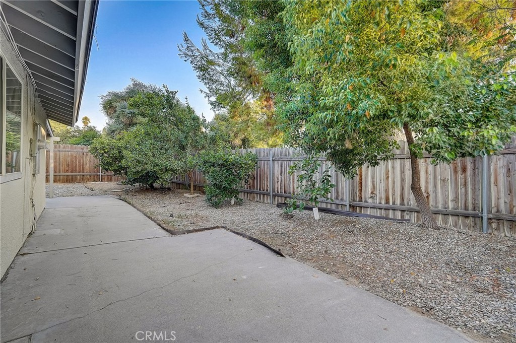 5030 Kensington Way Riverside, CA 92507 - Photo 18 of 18 a view of a backyard with large trees and wooden fence