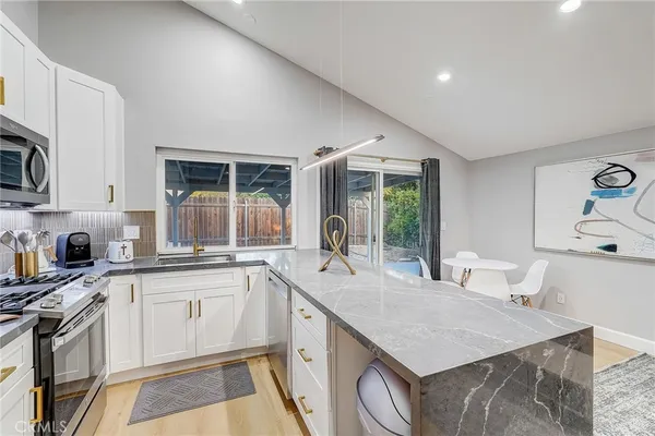 a kitchen with a refrigerator a stove a sink and a microwave