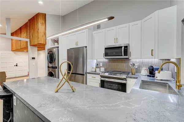 a kitchen with a sink appliances and cabinets
